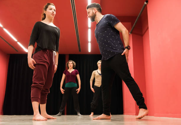 Young man and woman interacting while performing dance in the class